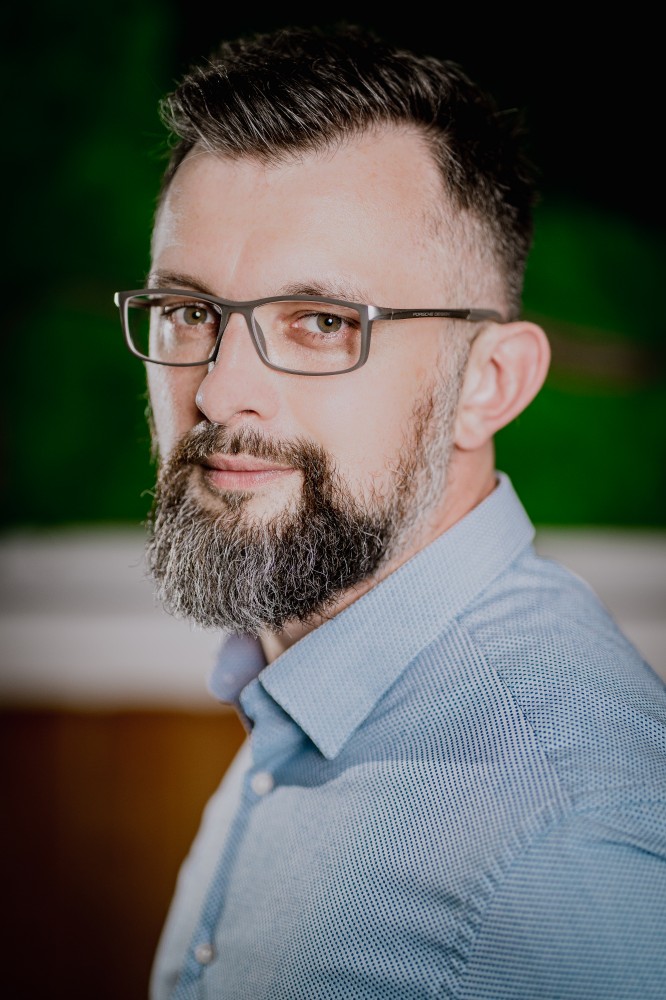 CEO agencji Digibit Grzegorz Hampel to brodaty mężczyzna w okularach.
